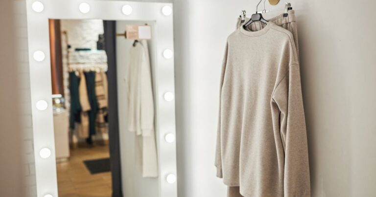 Peça de roupa em tom neutro pendurada em ambiente interno, representando moda confortável e funcional