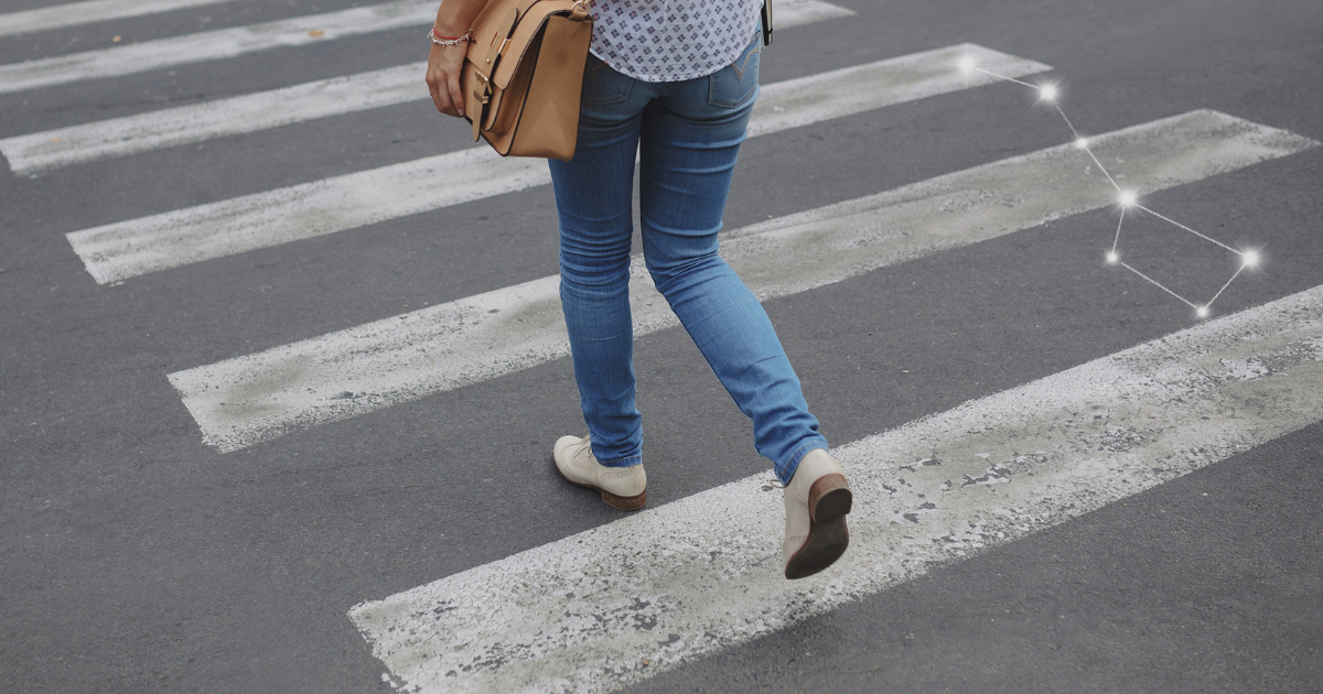 Pessoa atravessando a rua usando calçado adequado para uso prolongado no dia a dia